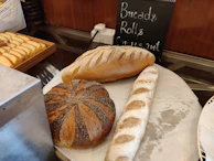 Display of various breads including rye, sourdough, and multigrain at the bakery counter.