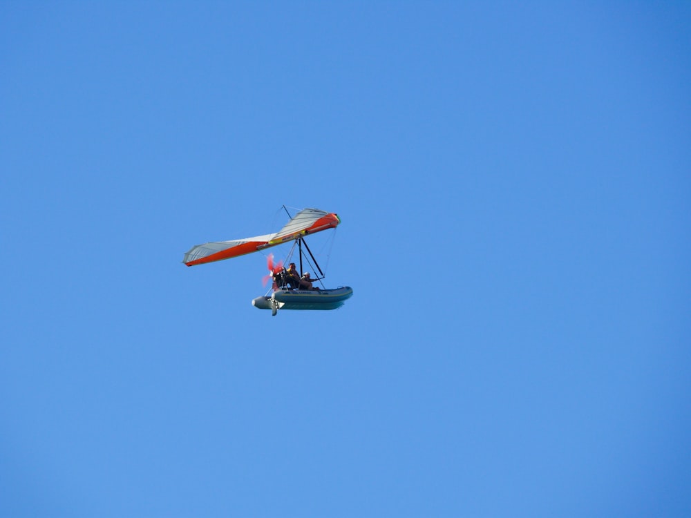 a small airplane flying through a blue sky