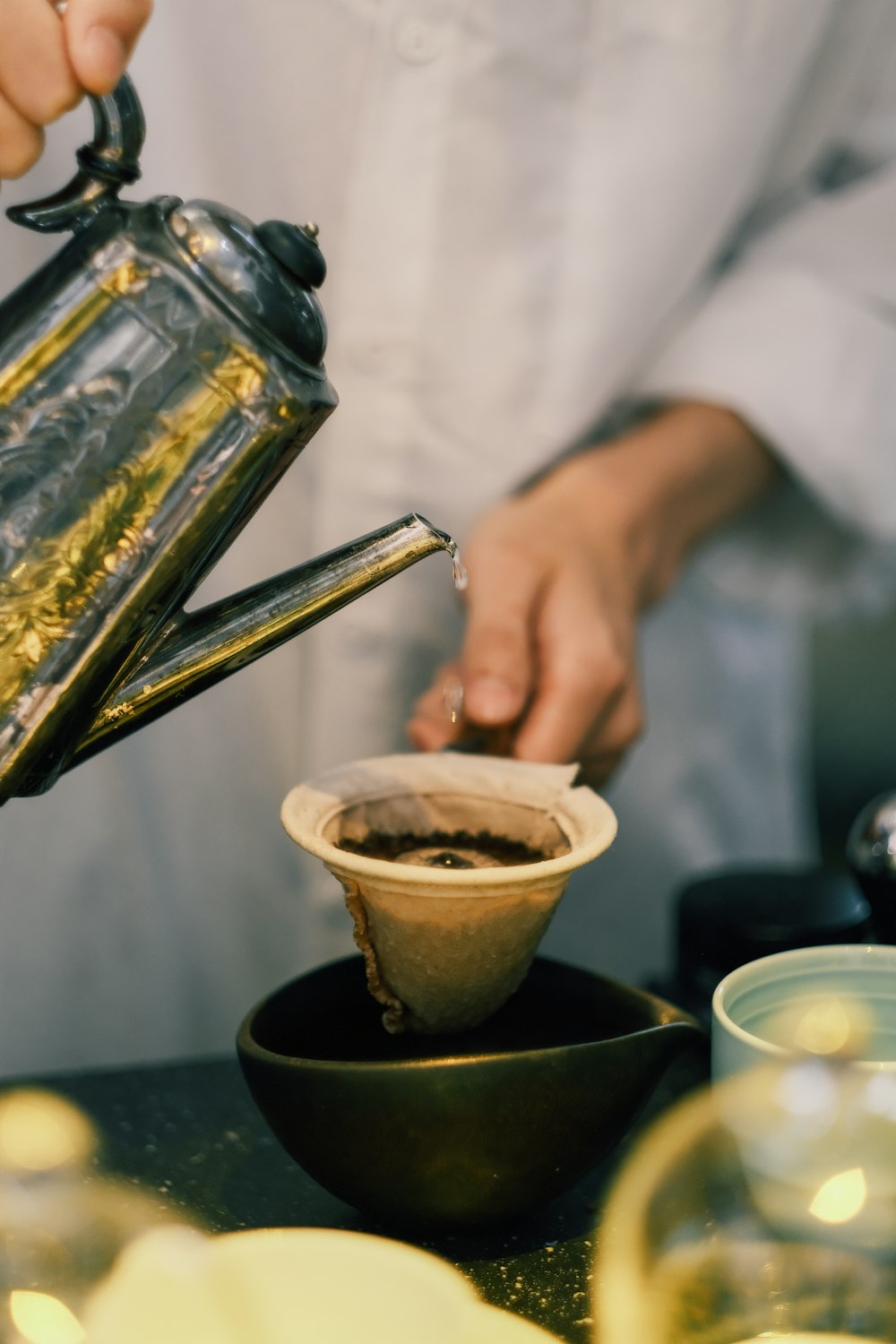 a person pouring coffee into a cup on a table