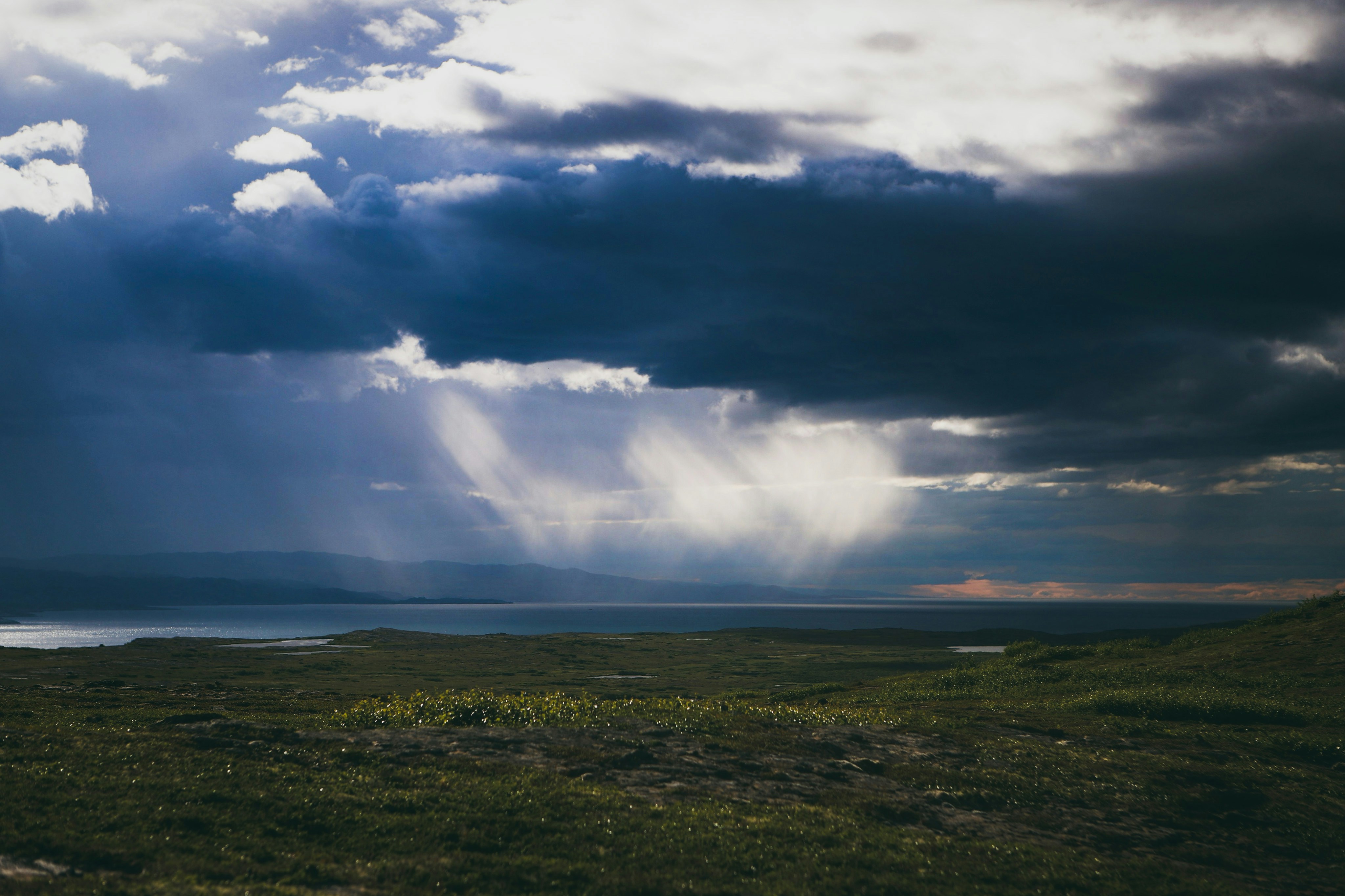 the sun shines through the clouds over the water