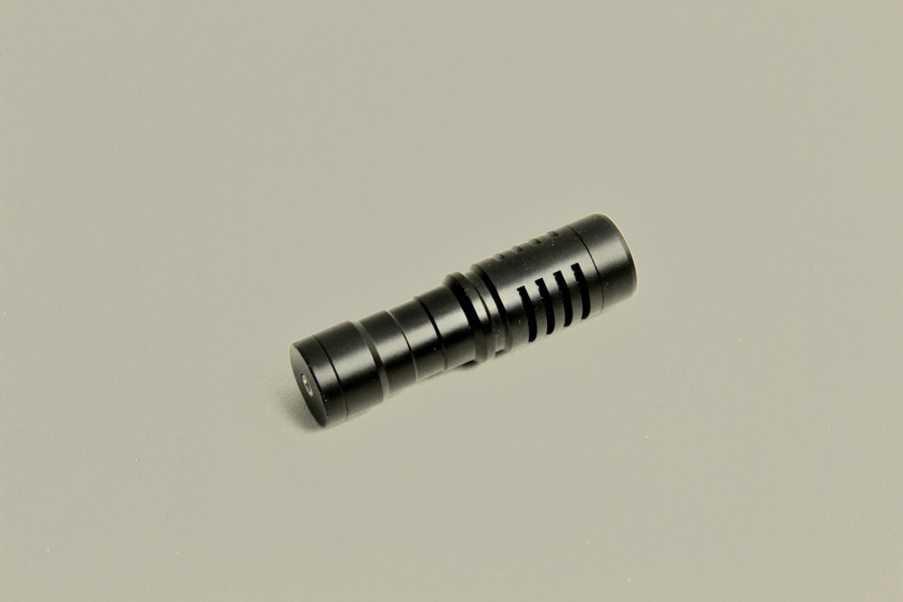 a close up of a flashlight on a white surface