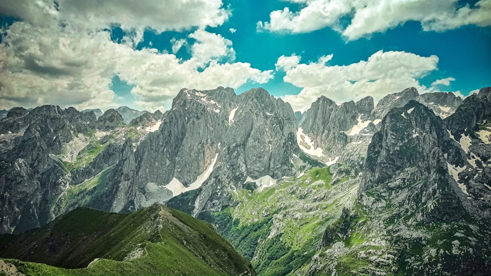 a view of a mountain range from the top of a hill