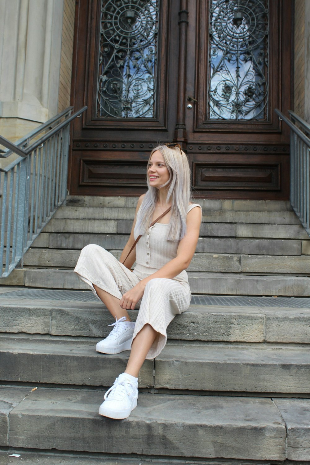 a woman sitting on the steps of a building