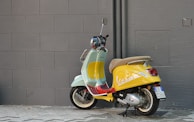 An artistic wallpaper featuring a Vespa surrounded by abstract designs.
