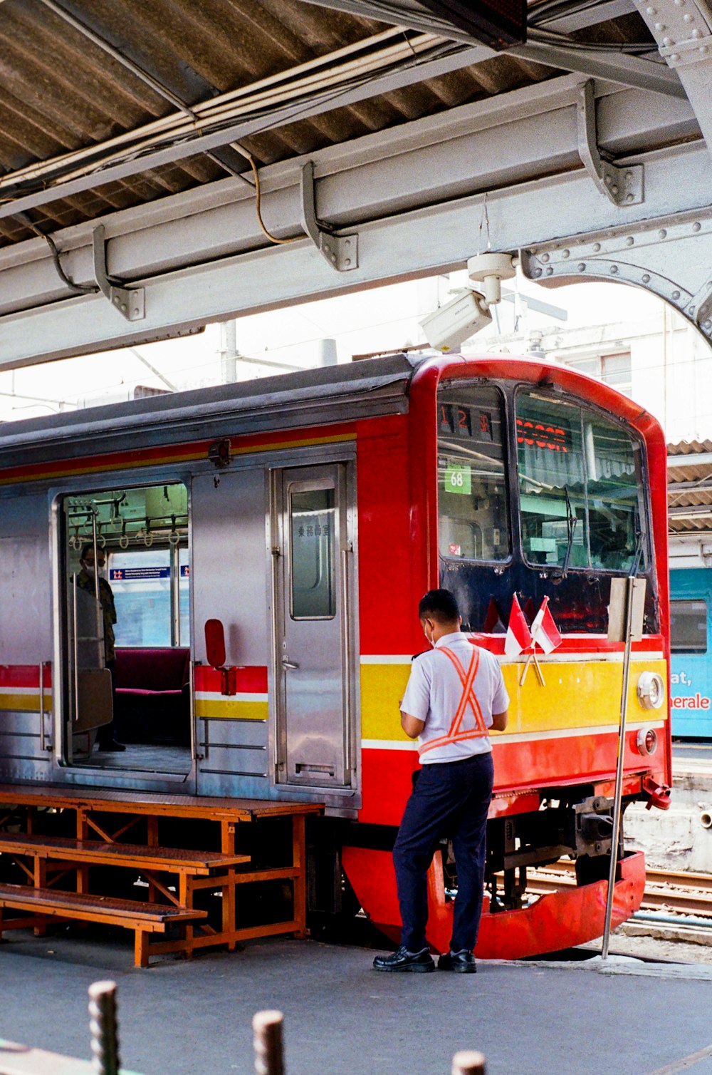 Un uomo in piedi accanto a un treno rosso e giallo