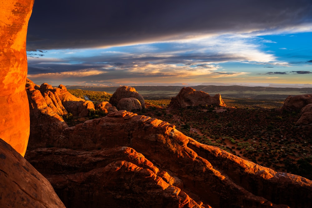 the sun is setting over the mountains and rocks