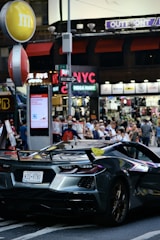 A modern sprinter van cruising along a busy New York City street.
