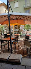 An elegant outdoor café setting with Sombraviva umbrellas providing shade.