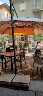 A custom-designed awning shading a cozy outdoor café seating area.