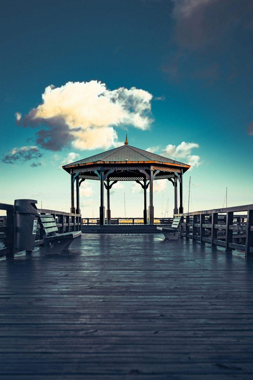 a pier with a gazebo on a cloudy day