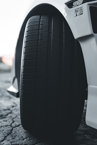 Close-up of a truck tire being inspected with a smartphone showing the driverproof app interface.