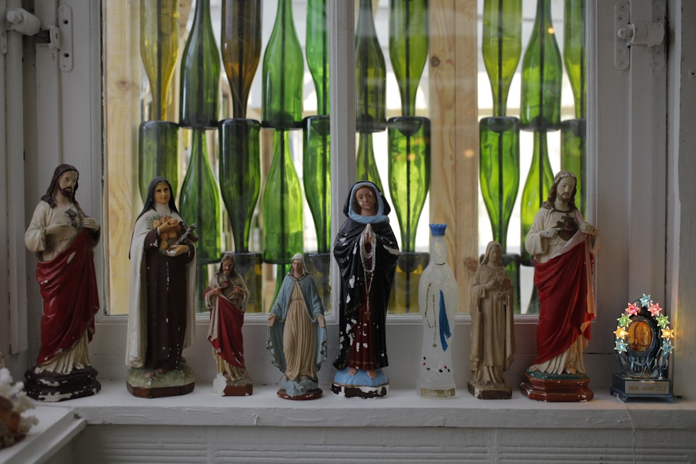 a group of statues sitting on top of a window sill