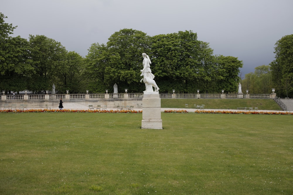 a statue in the middle of a grassy field