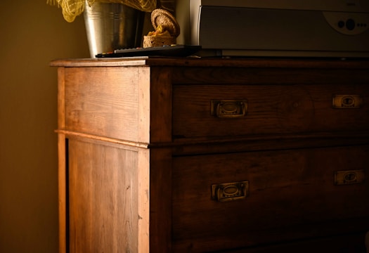 A sleek mid-century modern dresser with restored wood grain and brass handles.