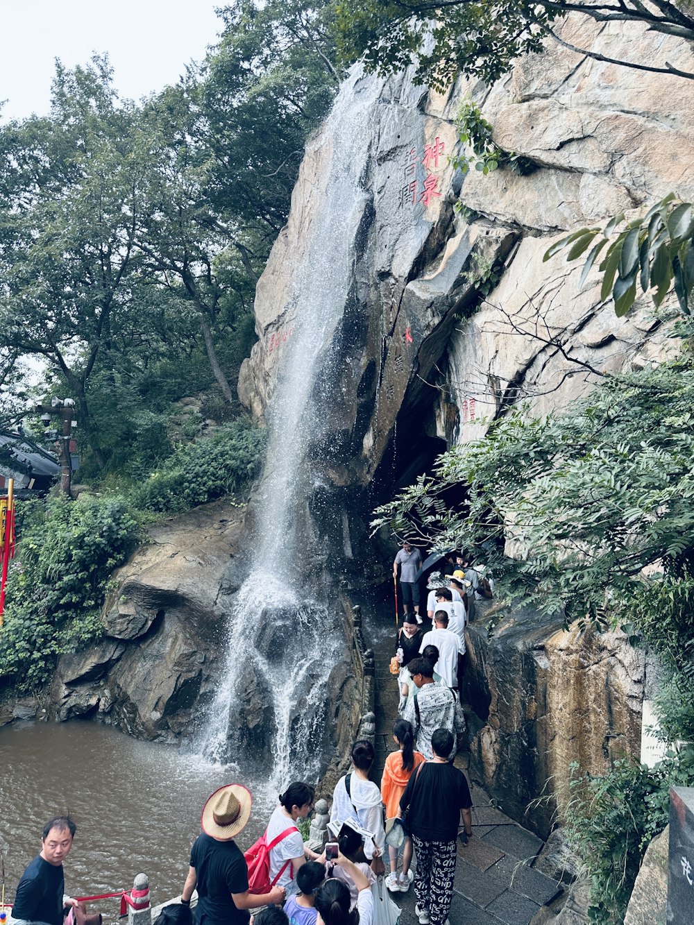 a group of people standing in front of a waterfall