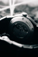 Macro shot of the watch’s brushed stainless steel case profile against a warm off-white background.
