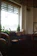 Cozy corner of lâ perla coffe bistro with sunlight streaming through rustic windows.