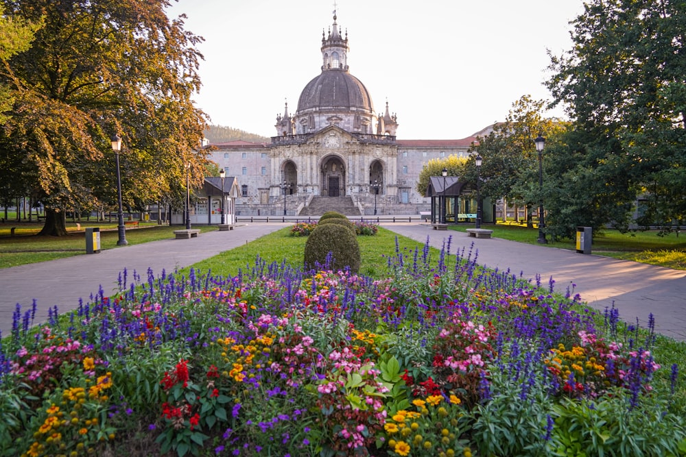 un grand bâtiment avec un dôme et un jardin en face