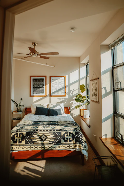Kamar tidur sederhana dengan kipas angin dan cahaya pagi