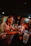 A cozy neon-lit bar corner with smiling patrons enjoying drinks together.