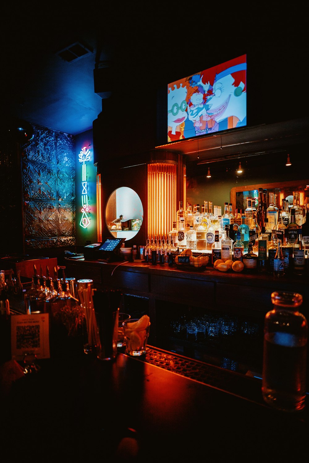 a dimly lit bar with liquor bottles and liquor glasses