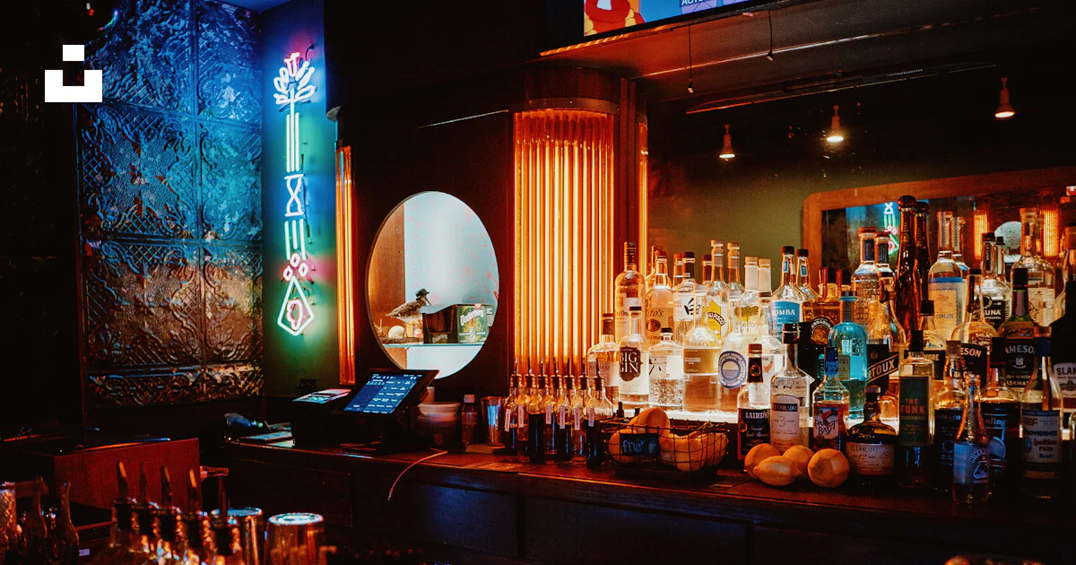 A dimly lit bar with liquor bottles and liquor glasses photo – Free Bar ...