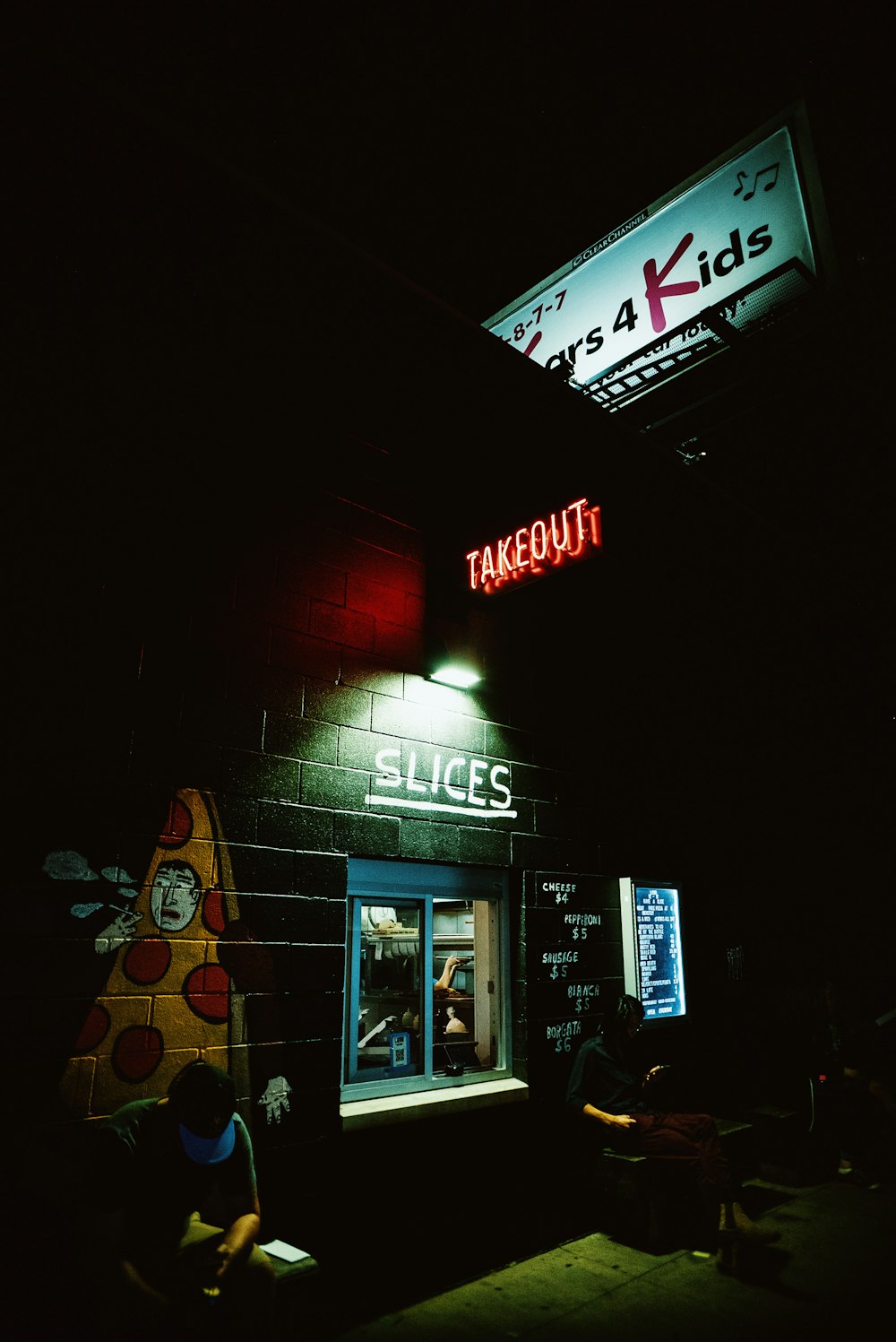 a pizza hut with a neon sign above it