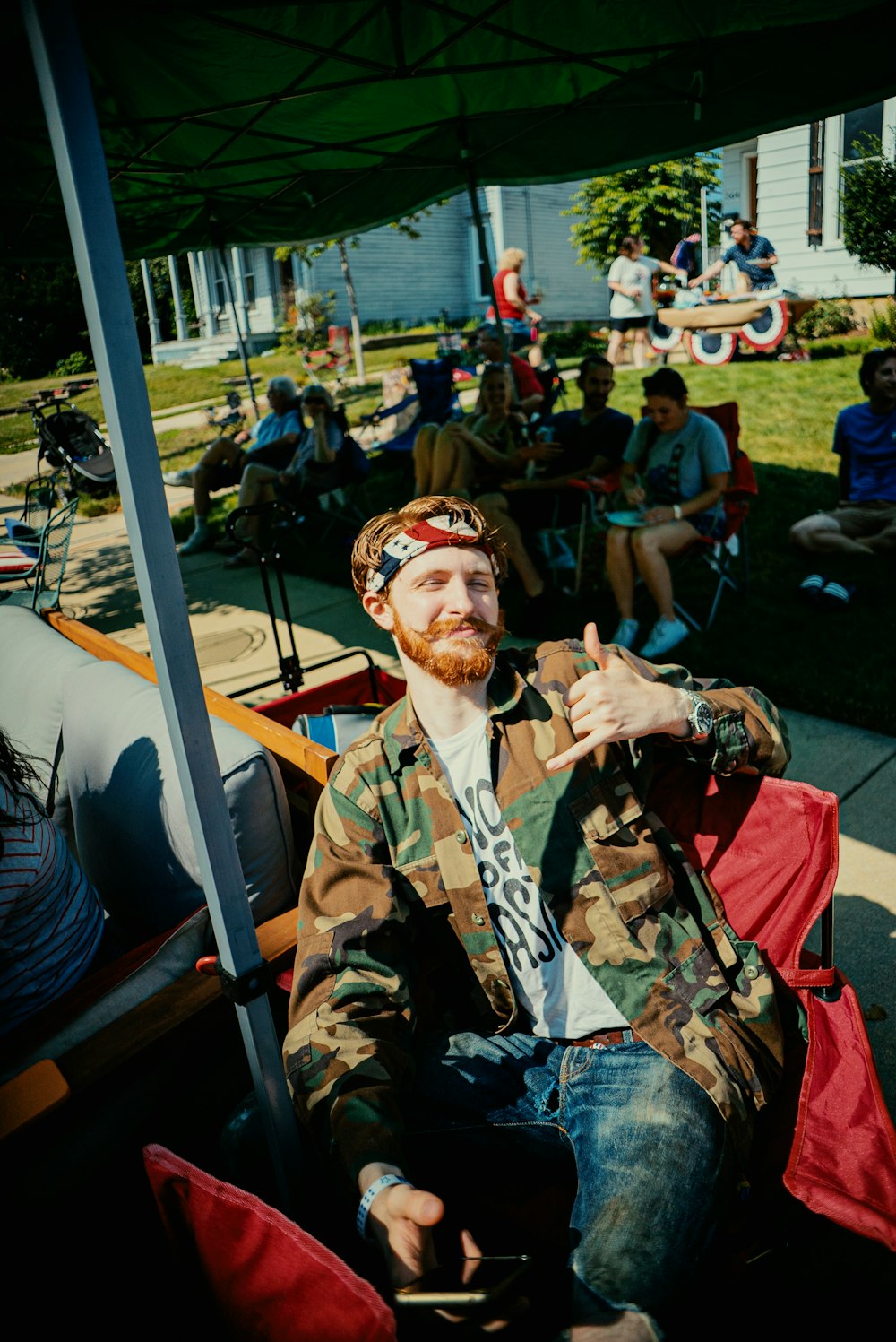 a man with a beard sitting under an umbrella