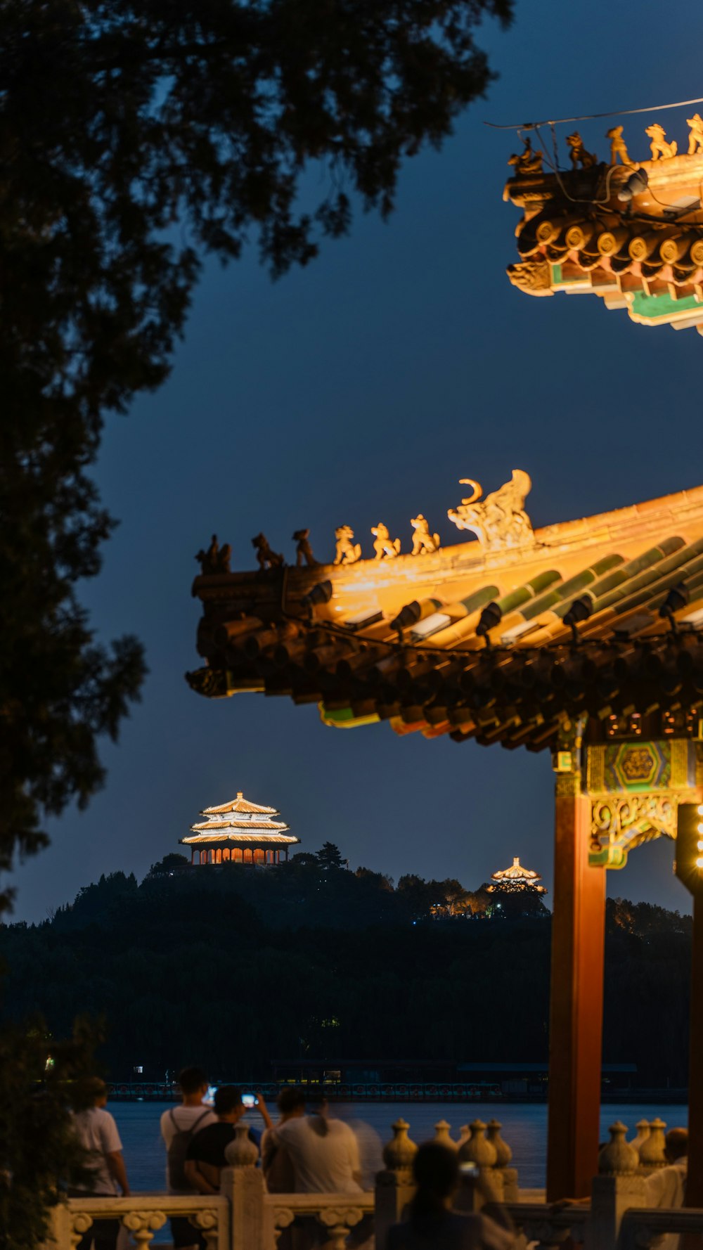 a group of people sitting around a pavilion at night