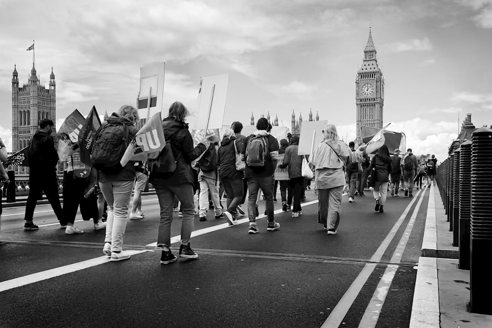 a group of people walking down a street holding signs