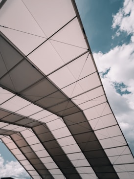 the underside of a bridge under a cloudy blue sky