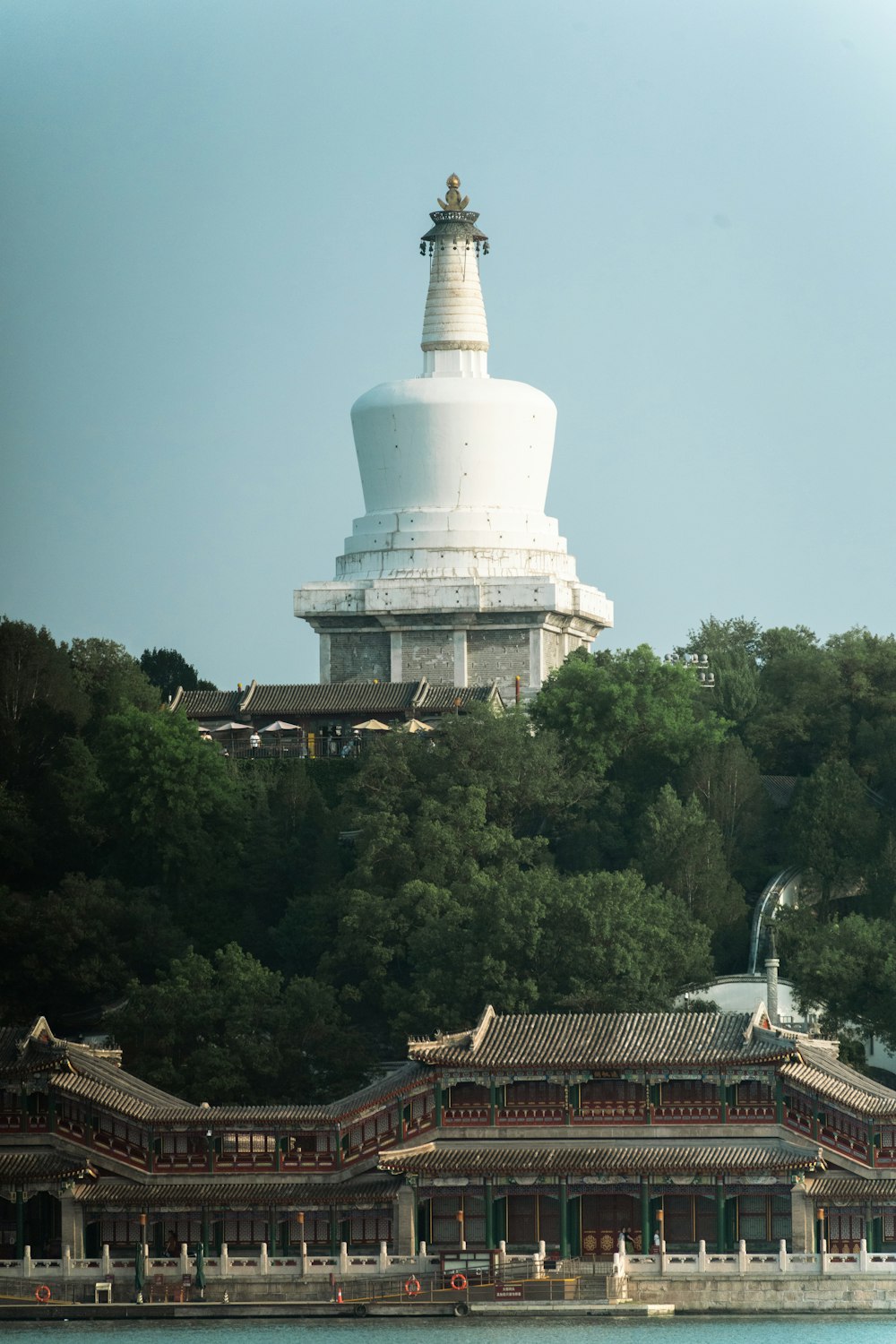 a large white building sitting on top of a lush green hillside