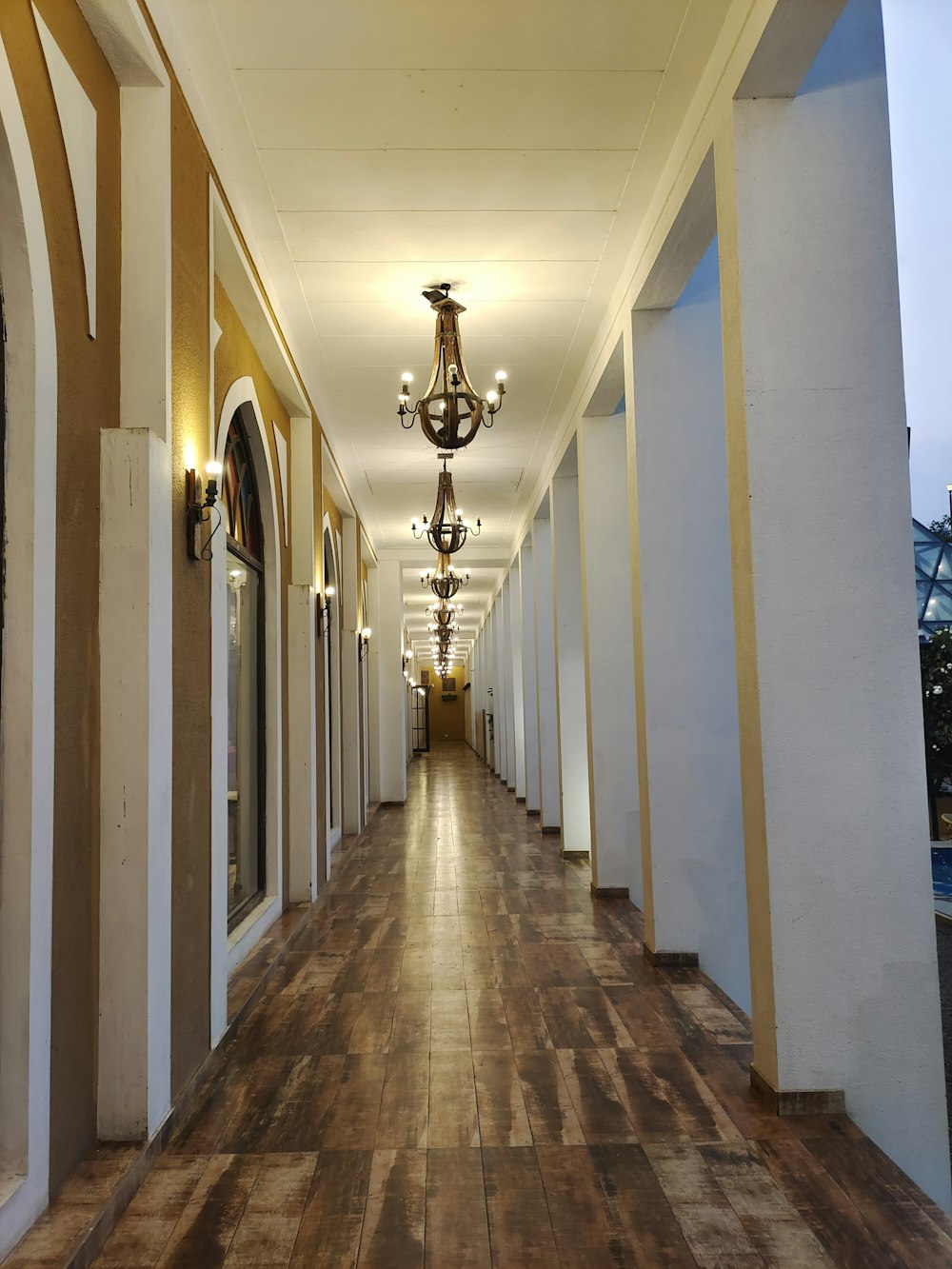 a long hallway with a chandelier hanging from the ceiling