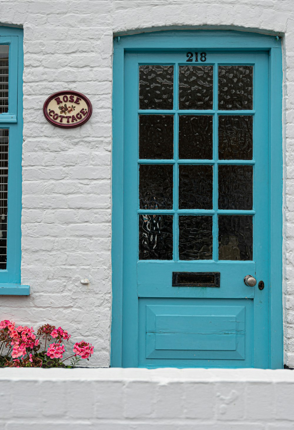a blue door and window on a white brick building