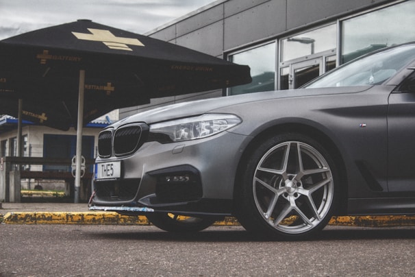 Front view of a sleek new sedan parked outside Auto Adatou Cissé showroom in Bamako.