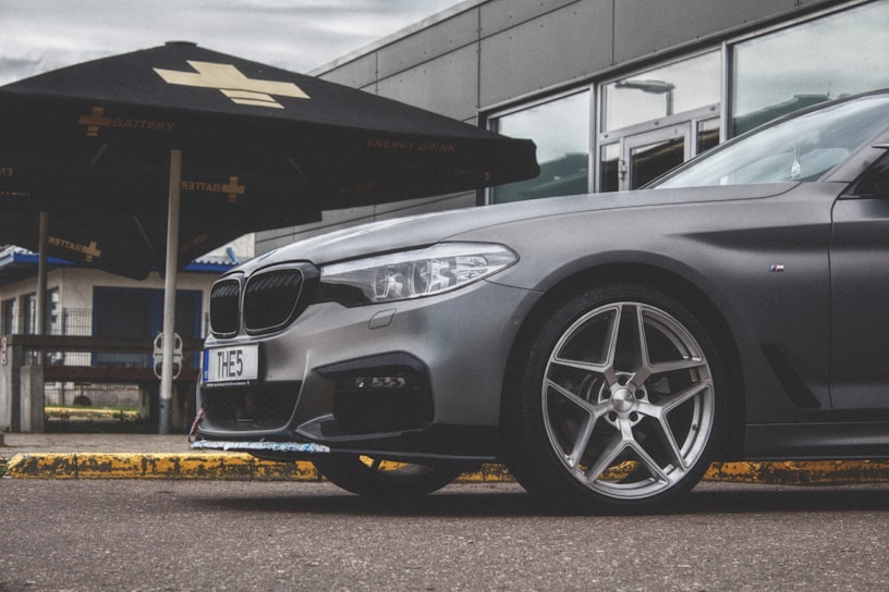 A sleek, modern car parked in a sunlit driveway, symbolizing personal vehicle protection.