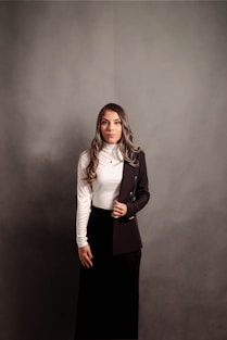 a woman in a skirt and jacket posing for a picture