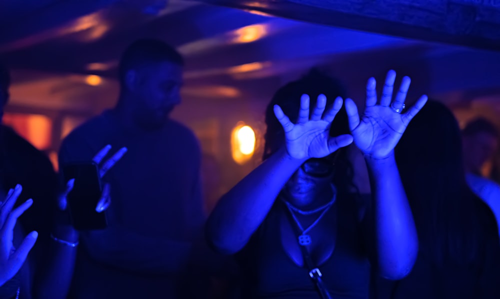 a group of people standing in a room with their hands up