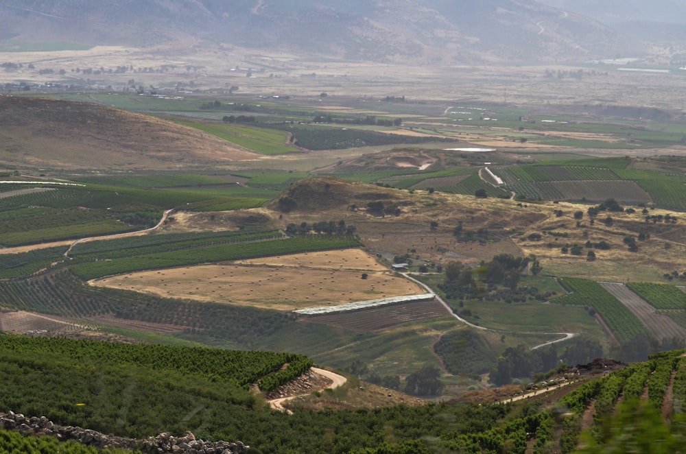 a scenic view of a valley with a winding road