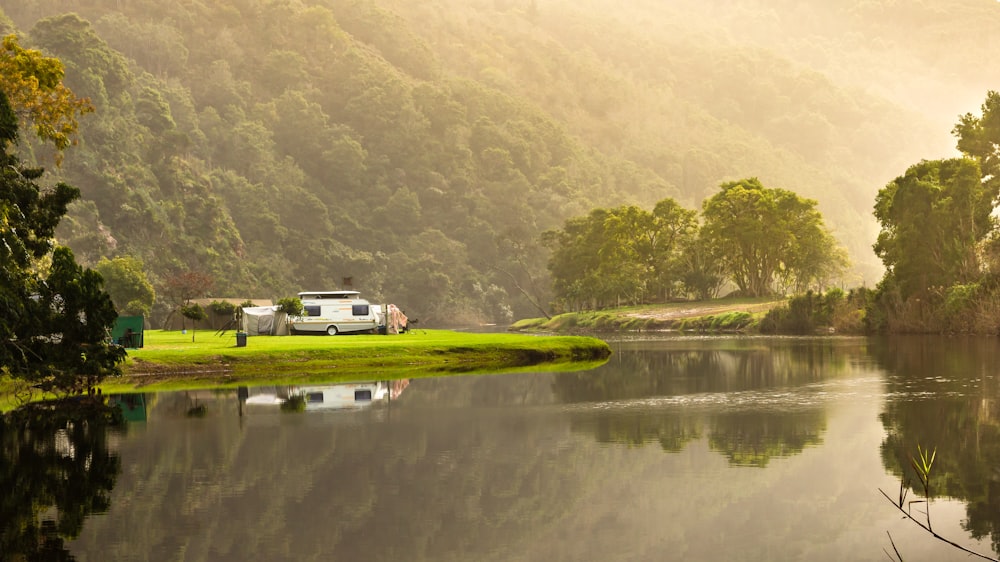 a camper parked on the shore of a lake