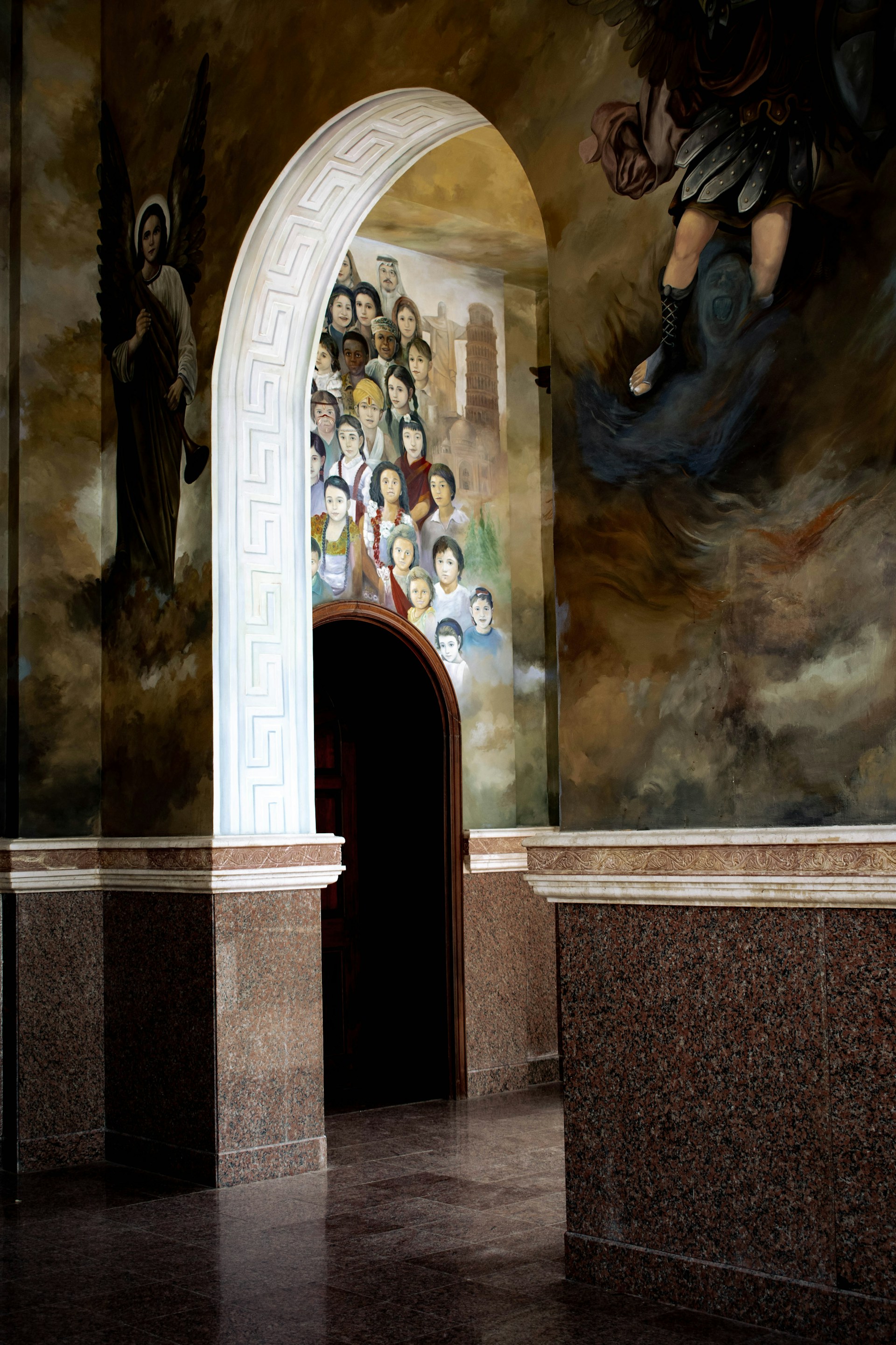 A stunning wall mural made of colorful onyx and marble, depicting a serene landscape in a grand hallway.