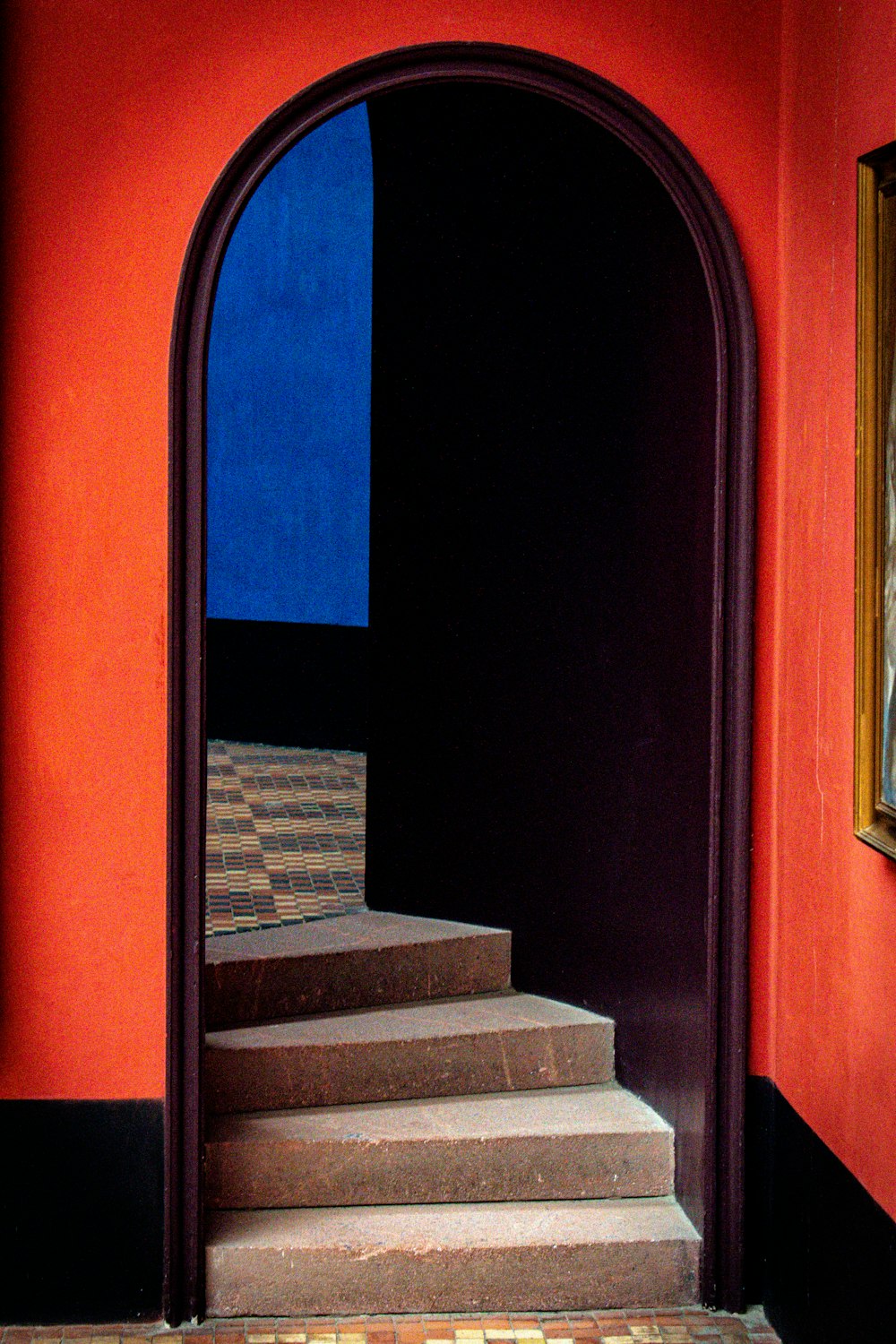 a doorway leading to a stairway with a painting on the wall