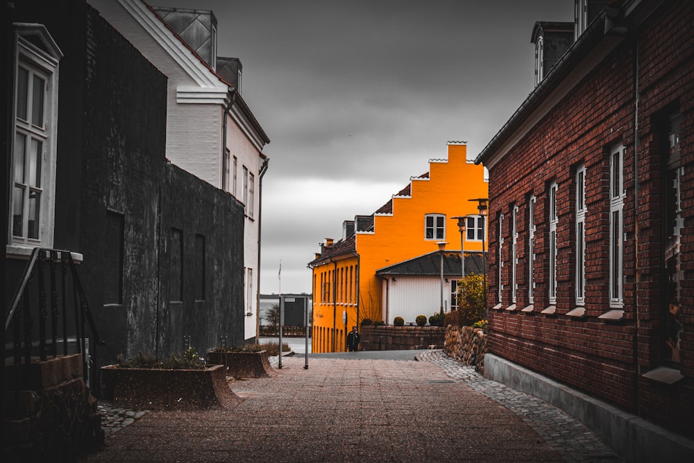 Un callejón estrecho con un edificio amarillo al fondo