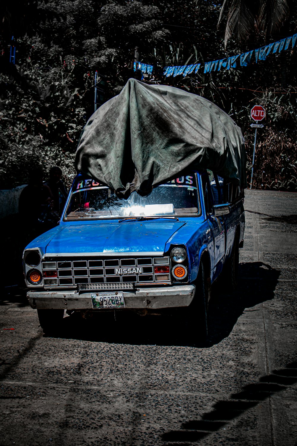 a blue car with a tarp on top of it