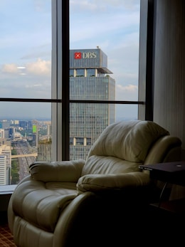 a recliner chair in front of a window overlooking a city