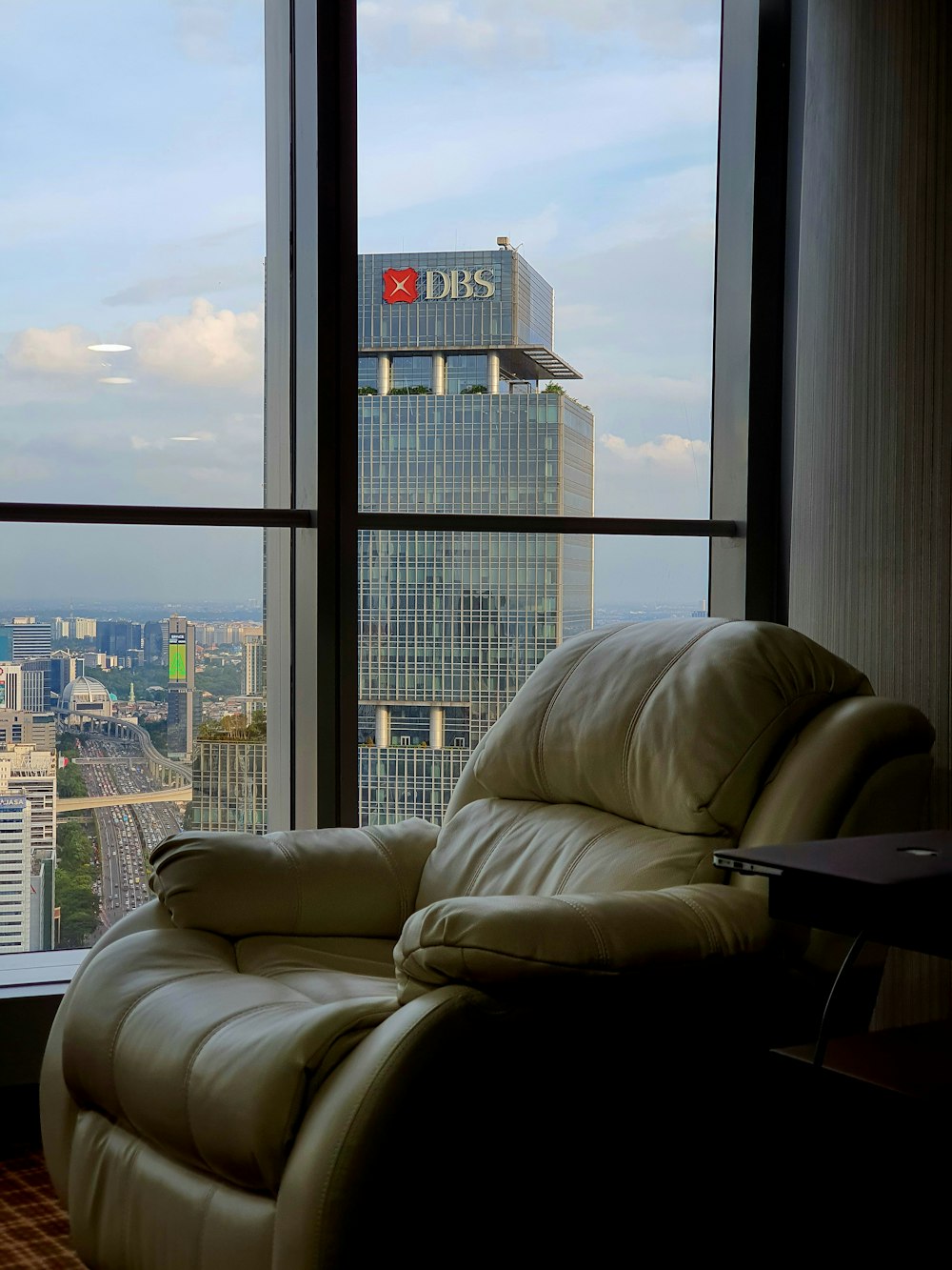 uma cadeira reclinável em frente a uma janela com vista para uma cidade