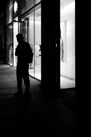 Close-up of a business owner proudly standing in front of their Siliguri storefront.