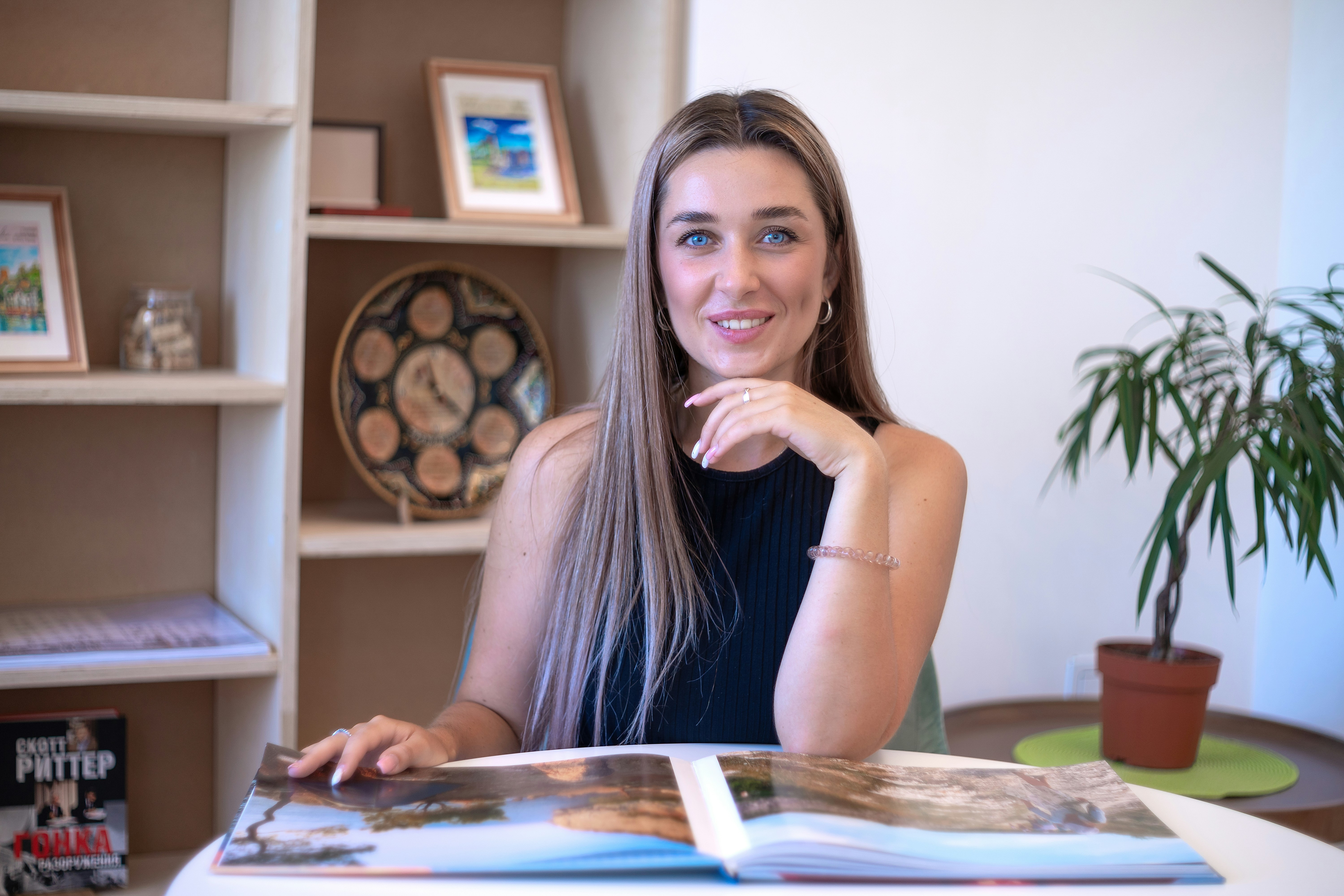 a woman sitting at a table with a book in front of her