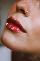 a close up of a woman's face with a nose ring