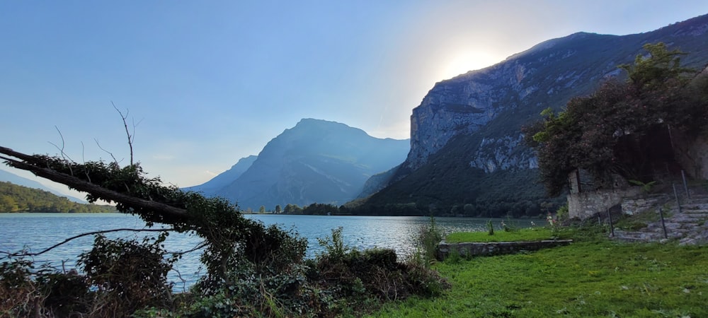 the sun is shining over a mountain lake